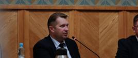 Spotkanie inaugurujące działalność Zespołu do spraw wsparcia młodzieżowych drużyn pożarniczych, przemawia minister Przemysław Czarnek, siedzi przy stole, mówi do mikrofonu.