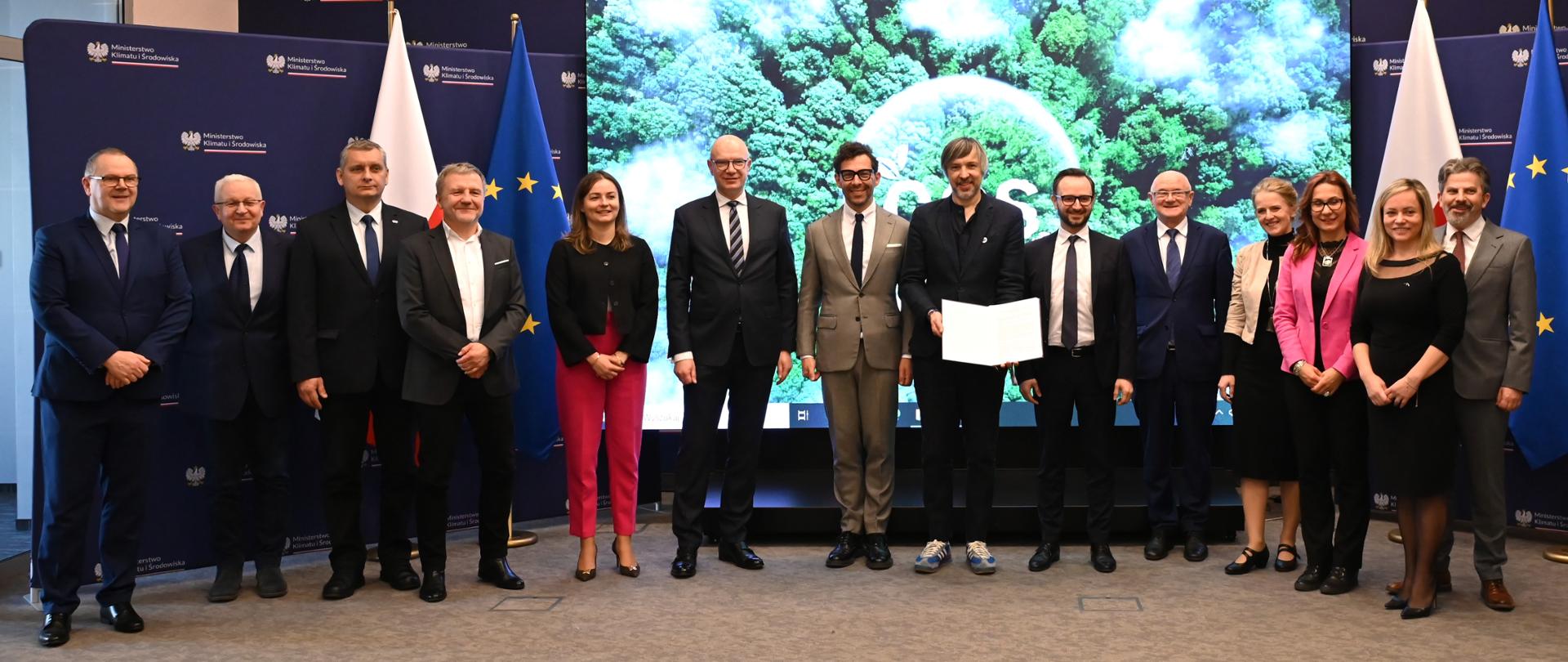Zdjęcie przedstawia sygnatariuszy listu intencyjnego dot. rozwoju technologii wychwytu, składowania i wykorzystania CO2. W tle widoczne są flagi Polski i UE.