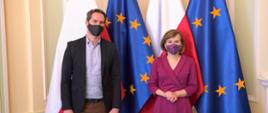 Minister Anna Krupka i Minister Péter Sárfalvi stoją przed flagami
