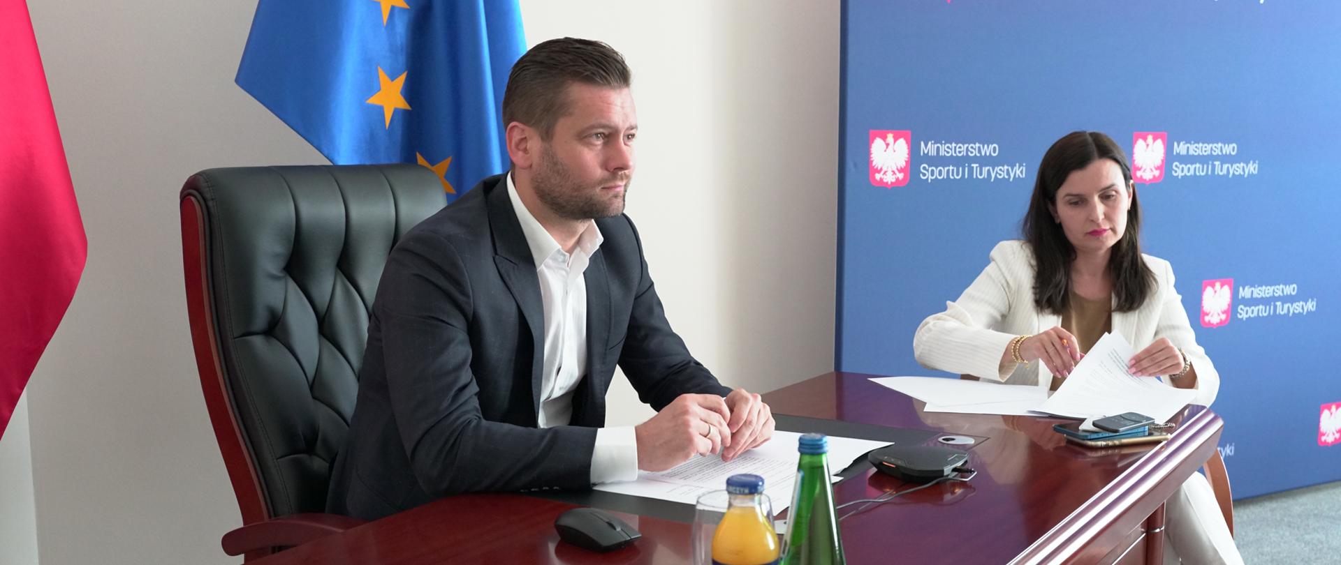 Drugie spotkanie ministrów ds sportu w sprawie wojny na Ukrainie i dalszych
sankcji dla Rosji i Białorusi - wideokonferencja. Minister Kamil Bortniczuk siedzi przy stole z panią dyrektor Departamentu Współpracy Międzynarodowej Joanną Żukowską-Easton.