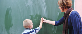Uczeń z nauczycielką przy tablicy