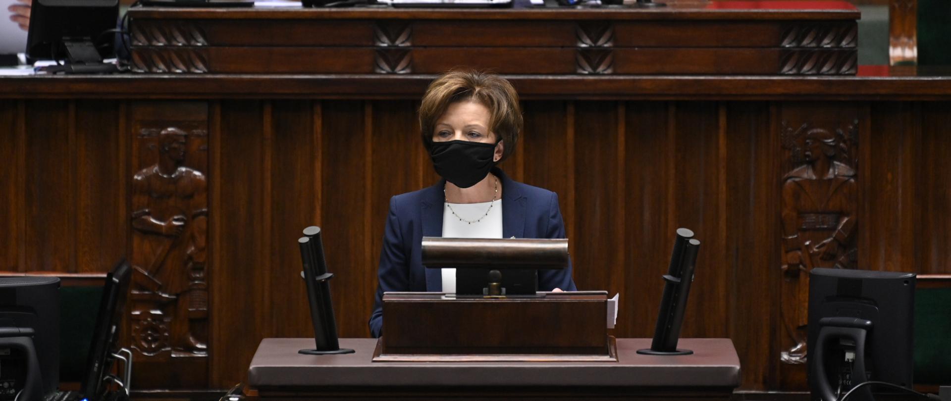 Minister Maląg stoi na mównicy sejmowej