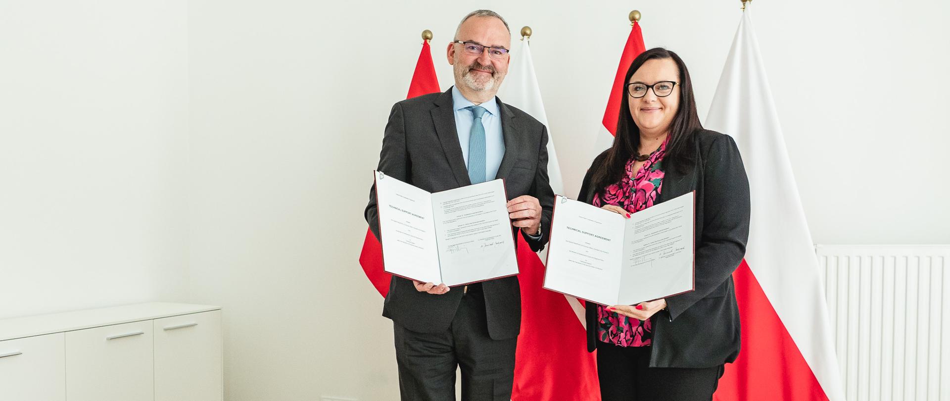 Wiceminister Małgorzata Jarosińska-Jedynak i Ambasador Konfederacji Szwajcarskiej w Polsce Fabrice Filliez pozują do zdjęcia z dokumentami w ręku