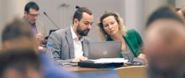 Na zadjęciu widać uczestników spotkania siedzących przy stole konferencyjnym