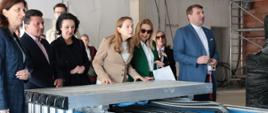 Minister funduszy i polityki regionalnej Katarzyna Pełczyńska-Nałęcz stoi przed maszyna obróbki drewna, obok niej stoją osoby, z którymi zwiedza BCU
