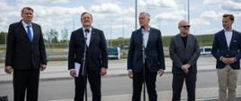 Minister Tomasz Siemoniak podczas spotkania z szefem MSW Litwy na przejściu granicznym w Budzisku. W tle samochody Straży Granicznej na drodze.