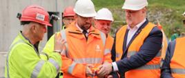 Minister funduszy i polityki regionalnej Grzegorz Puda podczas operacji finalnego przebicia ostatniej nawy w tunelu drążonym w masywie Baraniej Góry, minister trzyma w dłoniach przycisk do detonacji, po jego prawej stronie wicewojewoda śląski Jan Chrząszcz
