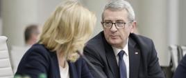Wiceminister edukacji i nauki Wojciech Murdzek na posiedzeniu Rady Wykonawczej ds. wdrażania Krajowej Polityki Miejskiej 2030, wiceminister siedzi przy stole i rozmawia z wiceminister pracy i polityki społecznej Barbara Sochą