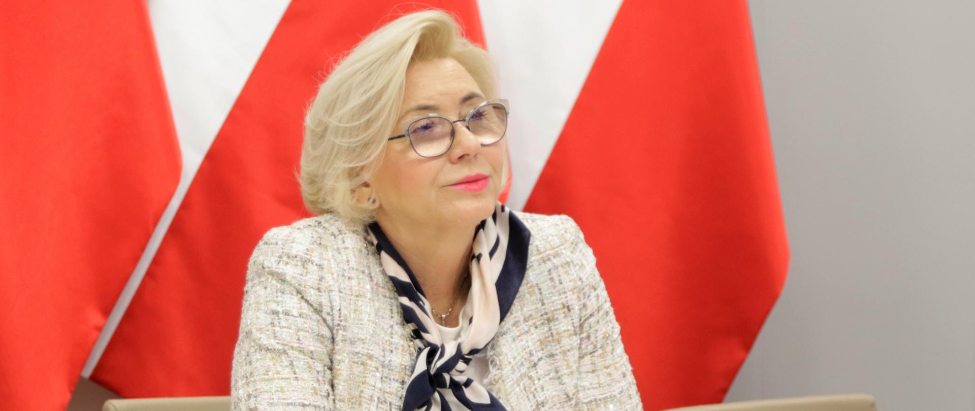 Wiceminister Marzena Machałek - Rada Bezpieczeństwa w edukacji, wiceminister Marzena Machałek siedzi przy biurku podczas spotkania, słucha wypowiedzi innych uczestników.