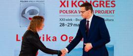 Premier Mateusz Morawiecki podaję rękę laureatce.