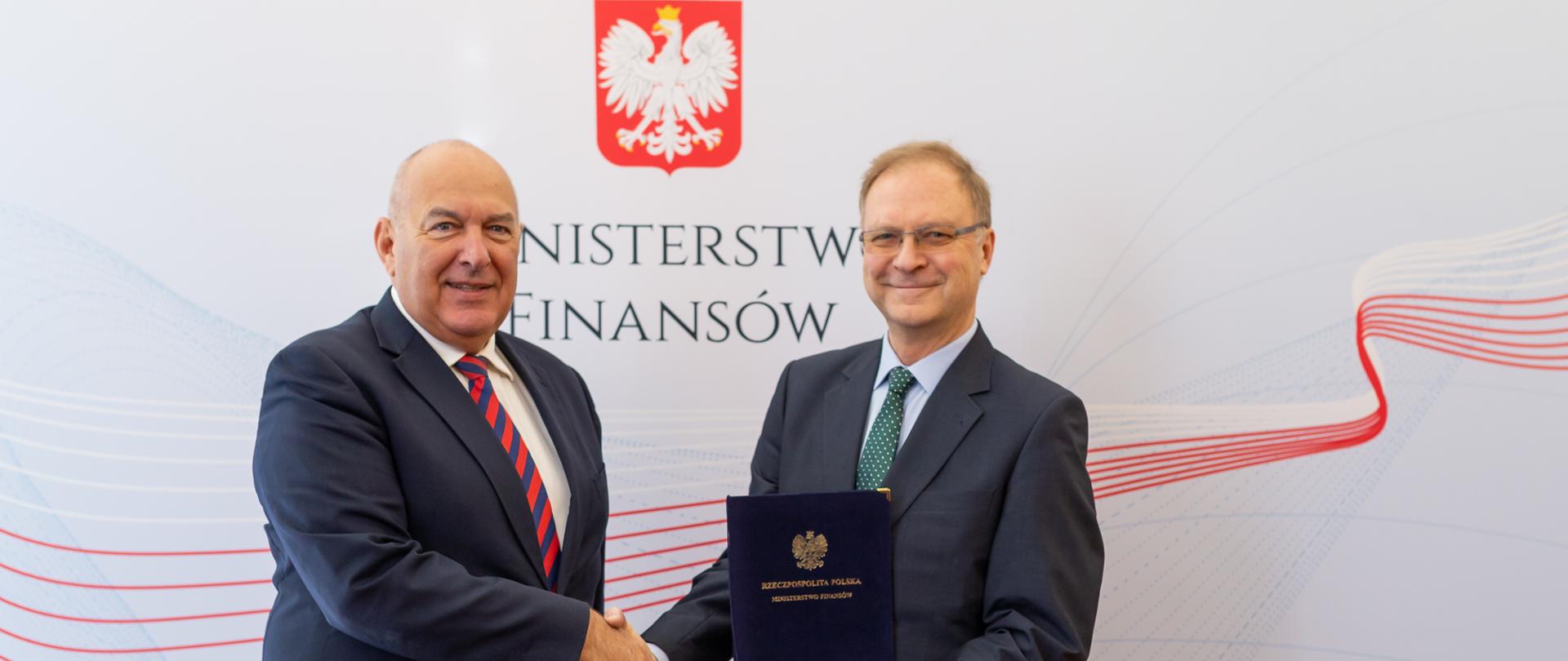 Minister Tadeusz Kościński i Antoni Repa na tle banera Ministerstwa Finansów