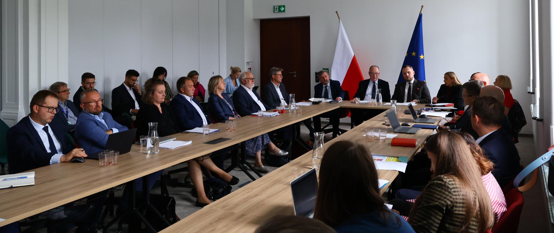 Spotkanie w Ministerstwie Energii. Uczestnicy siedzą przy stole konferencyjnym. W spotkaniu biorą udział Wiceminister Energii Konrad Wojnarowski oraz Wiceminister Klimatu i Środowiska, Główny Geolog Kraju Krzysztof Galos.