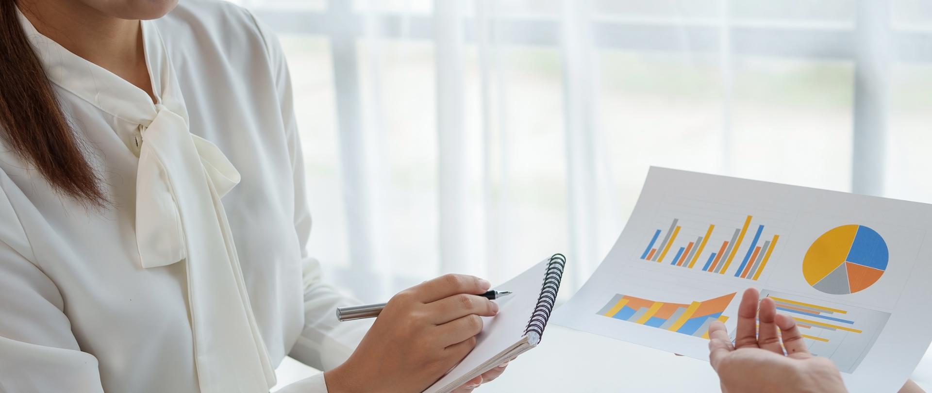 Close-up of a group of business meeting to discuss plan analyze graph and chart and calculate company performance, balance sheet, financial statement, income statement and deficit.