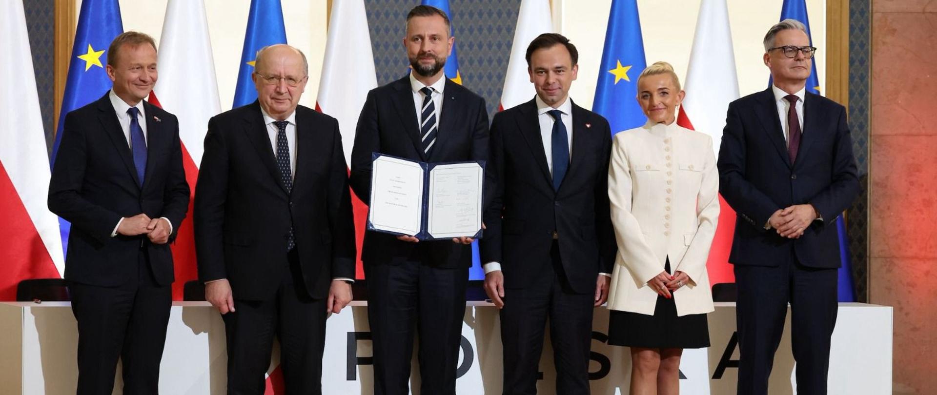Na zdjęciu wicepremier ministra obrony narodowej Władysław Kosiniak-Kamysz, minister finansów i gospodarki Andrzej Domański, prezes zarządu oraz pierwsza wiceprezes zarządu Banku Gospodarstwa Krajowego – Mirosław Czekaj, i prof. Marta Postuła oraz komisarze Unii Europejskiej – Piotr Serafin i Andrius Kubilius