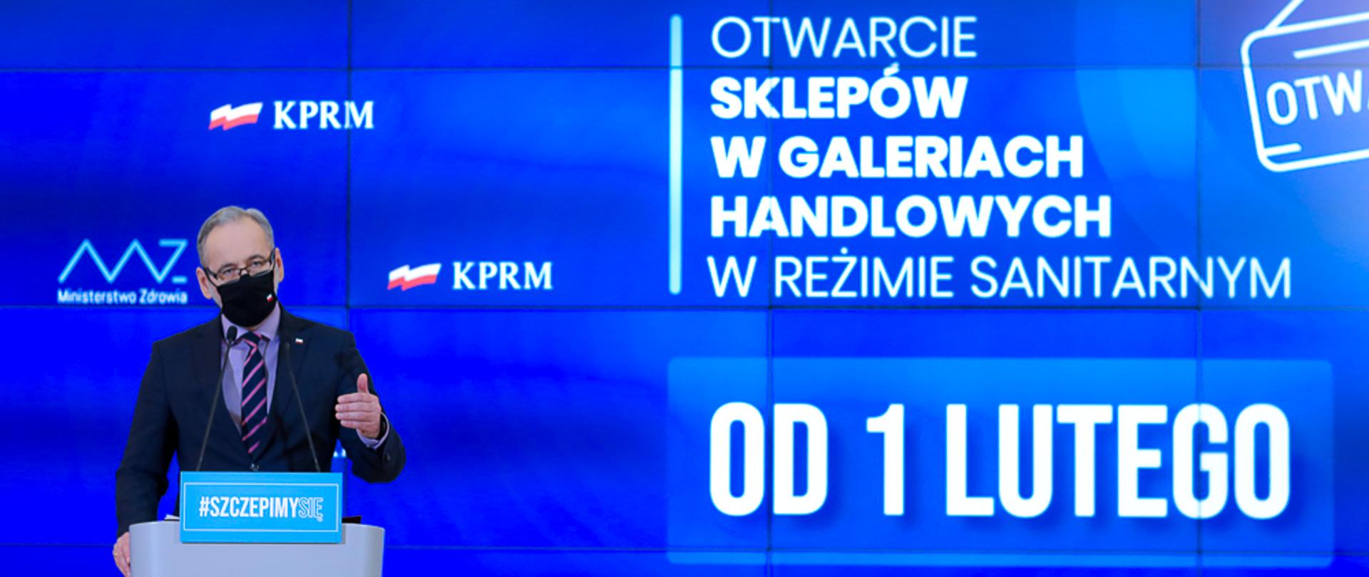 Minister Adam Niedzielski na tle prezentacji.