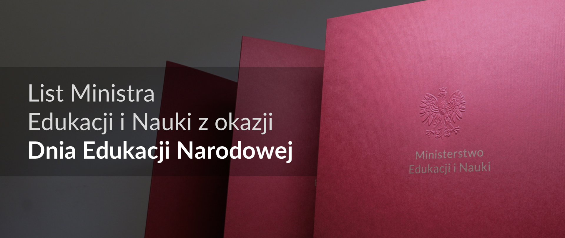 List ministra Edukacji i Nauki z okazji Dnia Edukacji Narodowej. Na zdjęciu z prawej strony widoczne pionowo ustawione bordowe teczki z napisem ministerstwo edukacji i nauki, po lewej stronie planszy napis list ministra edukacji i nauki z okazji dnia edukacji narodowej