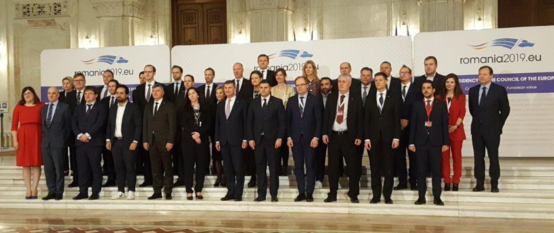 Grupa kilkudziesięciu osób stojąca na schodach w trzech rzędach.