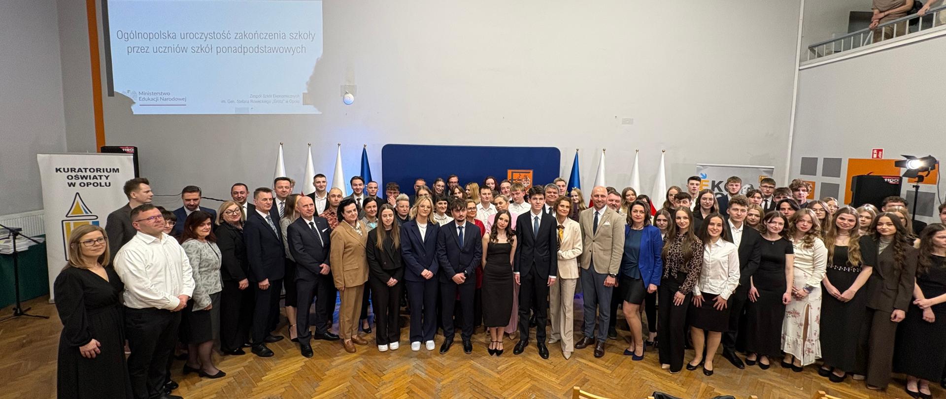 Na zdjęciu uczniowie klas maturalnych, kadra pedagogiczna Technikum nr 3 w Opolu oraz Minister Edukacji Barbara Nowacka. Wszyscy stoją i pozują do zdjęcia.