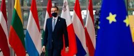 Premier na tle flag europejskich.