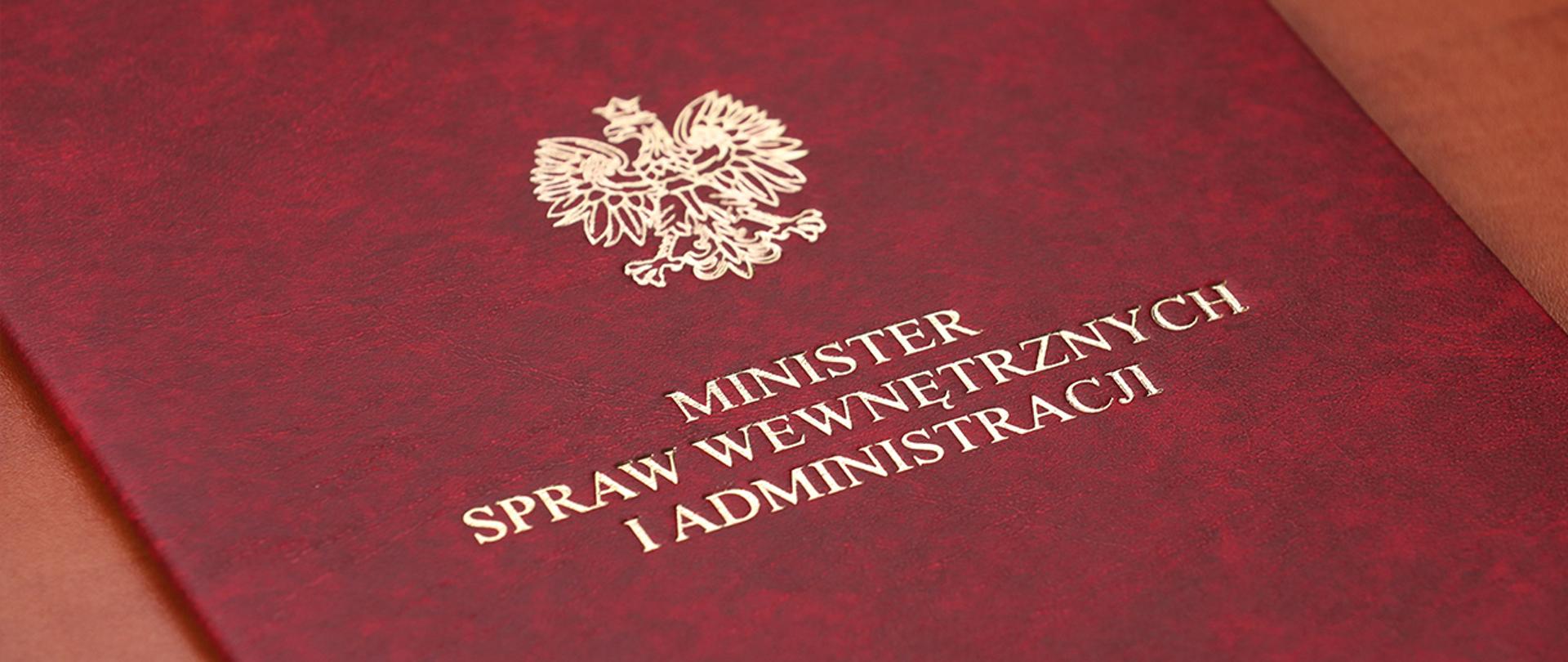 Na zdjęciu widać leżącą twardą teczkę Ministra SWiA. 