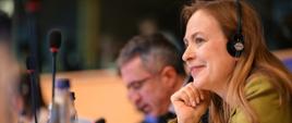 Minister Katarzyna siedzi ze słuchawkami na uszach