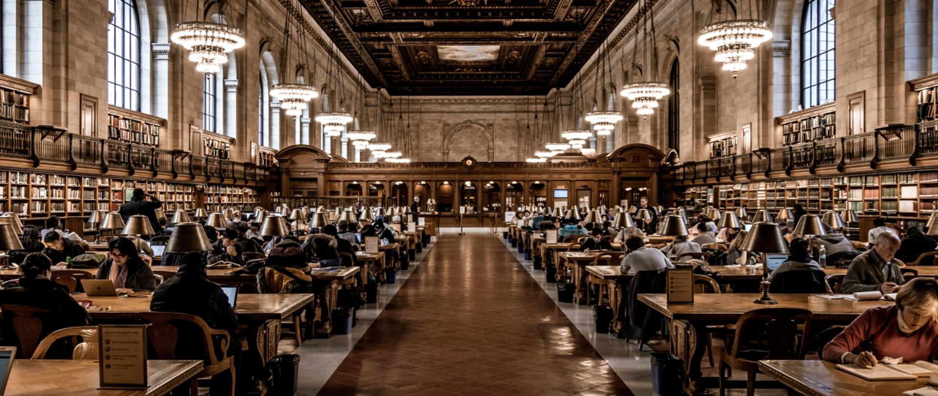 Aula biblioteczna, wielu studentów czyta książki