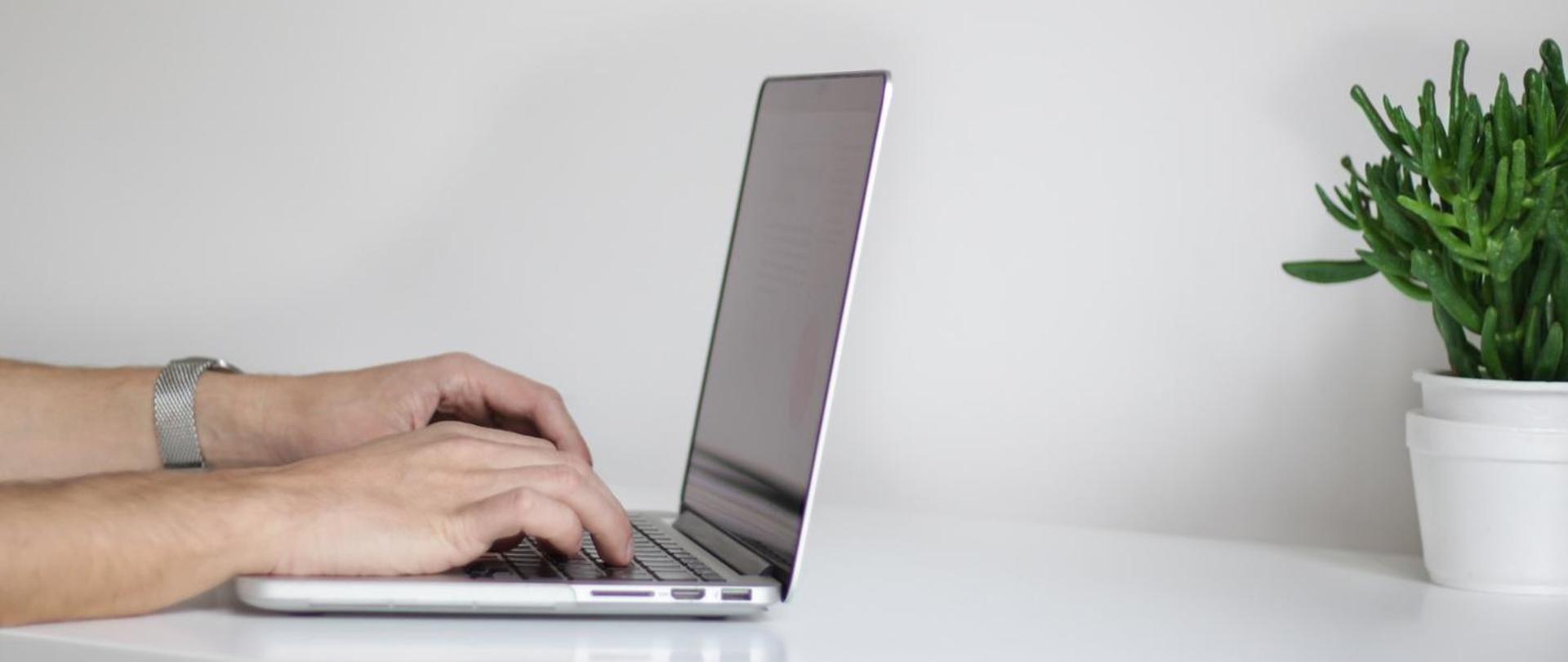 Dłonie na klawiaturze laptopa