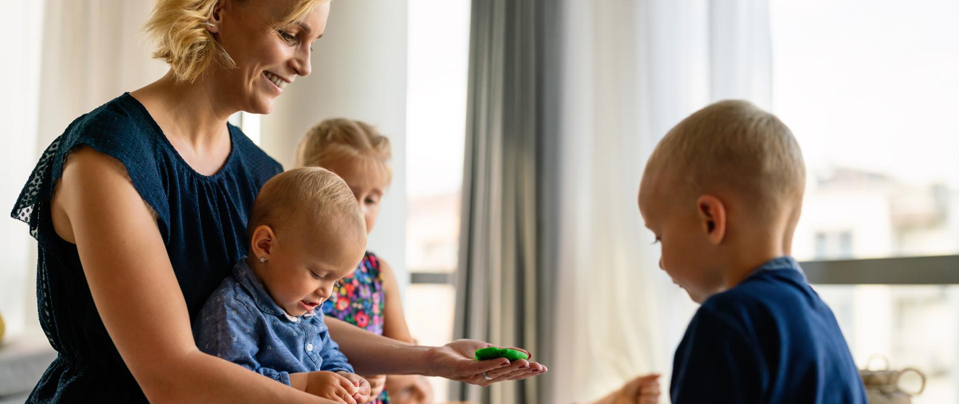 Mother teaches preschooler kids to do craft items. Family, children, education, happiness concept.