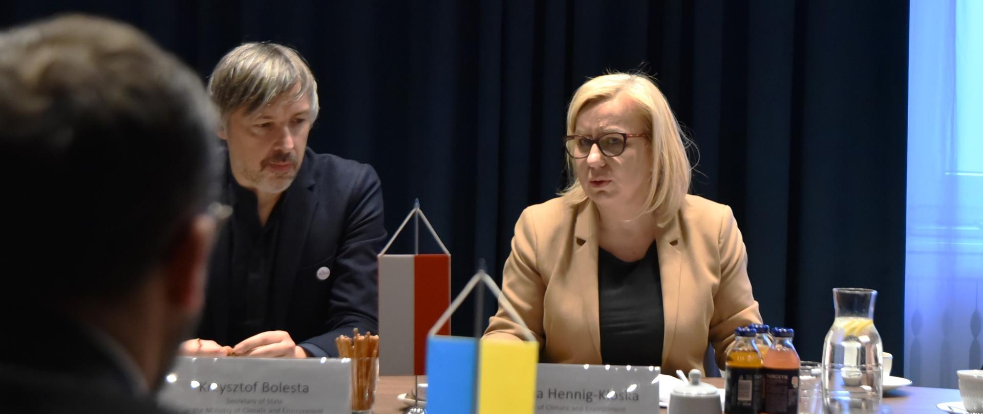 Zdjęcie przedstawia uczestników spotkania w sali konferencyjnej. Na drugim planie widać flagi Polski i Ukrainy
