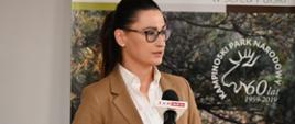 Wiceminister Małgorzata Golińska przemawia podczas uroczystości podpisania umów na budowę przeciwpożarowego systemu łączności radiowej wraz z mobilnym systemem wykrywania pożarów oraz budowę i modernizację systemu monitoringu przeciwpożarowego między NFOŚiGW a Kampinoskim Parkiem Narodowym.