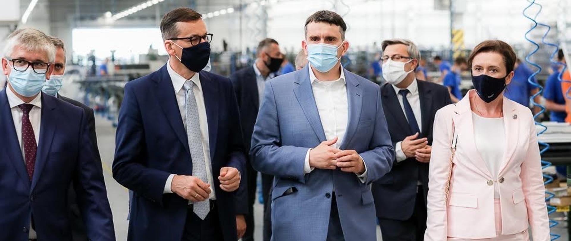 Premier oraz pozostali idą po siedzibie fabryki.