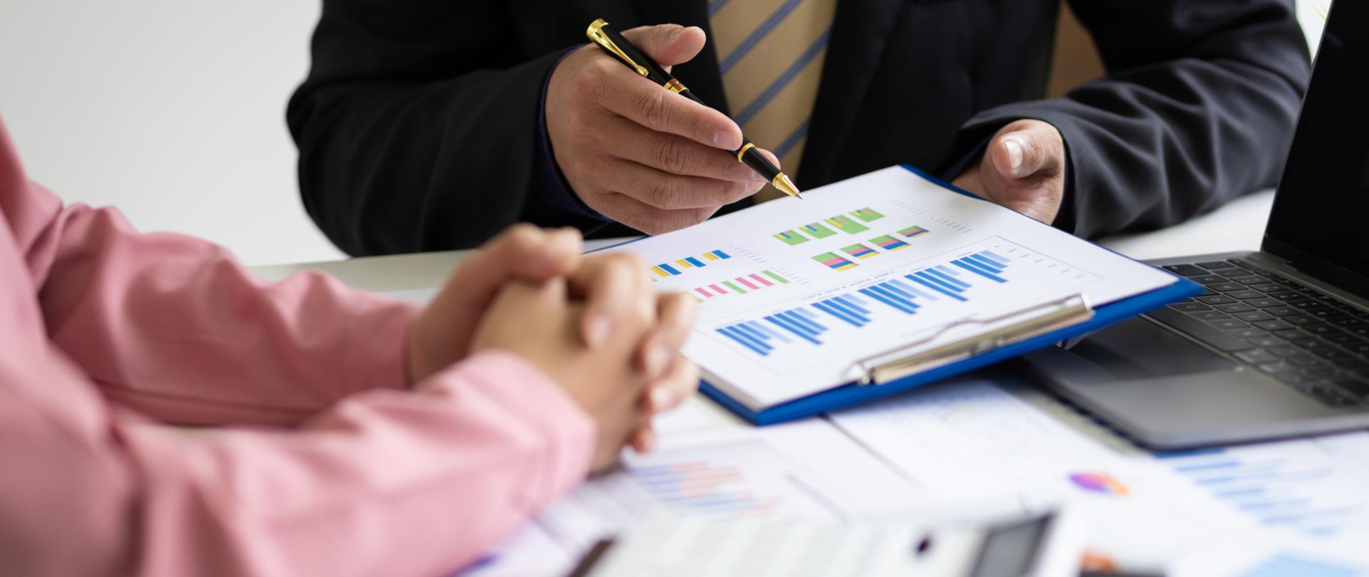 Businessmen meeting to discuss company sales report charts and analyze market strategies. Financial analysis and business investment planning