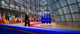 Premier na tle flag europejskich.