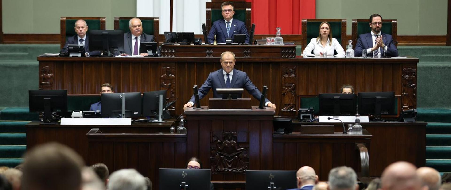 Premier Donald Tusk podczas wystąpienia w Sejmie w związku z naruszeniem polskiej przestrzeni powietrznej, W tle Marszałek Sejmu Szymon Hołownia.