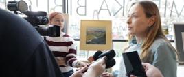 Minister funduszy i polityki regionalnej Katarzyna Pełczyńska-Nałęcz stoi przed dziennikarzami z mikrofonami