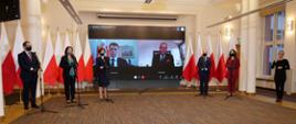 Uczestnicy konferencji prasowej (sześć osób) - stoją przed mikrofonami, wszyscy w maseczkach.
