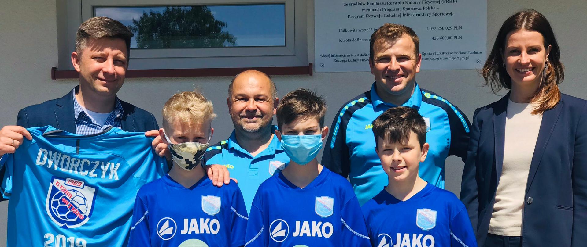 Minister Sportu na wspólnym zdjęciu z młodymi piłkarzami oraz działaczami sportowymi.
