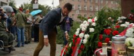 Na zdjęciu widoczny jest Minister Sportu i Turystyki Kamil Bortniczuk składający zielony wieniec z biało-czerwoną szarfą pod Pomnikiem Małego Powstańca.