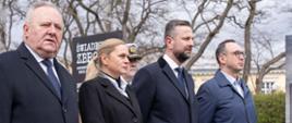 Minister Edukacji Barbara Nowacka stoi na świeżym powietrzu razem z innymi uczestnikami obchodów