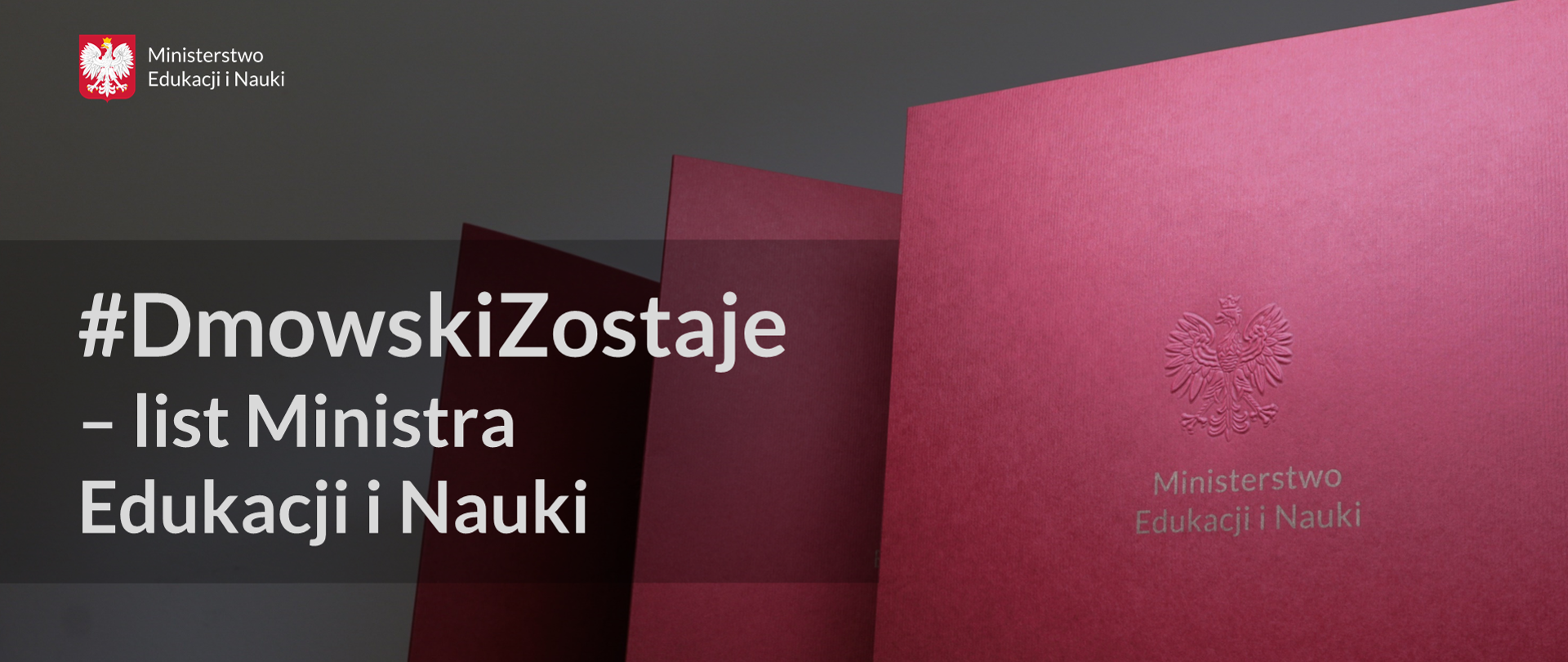 Po lewej stronie bordowe teczki z wytłoczonym orłem i złotym napisem Ministerstwo Edukacji i Nauki. Szare tło, a na nim po lewej stronie napis #DmowskiZostaje – list Ministra Edukacji i Nauki. Powyżej logotyp Ministerstwa Edukacji i Nauki. 