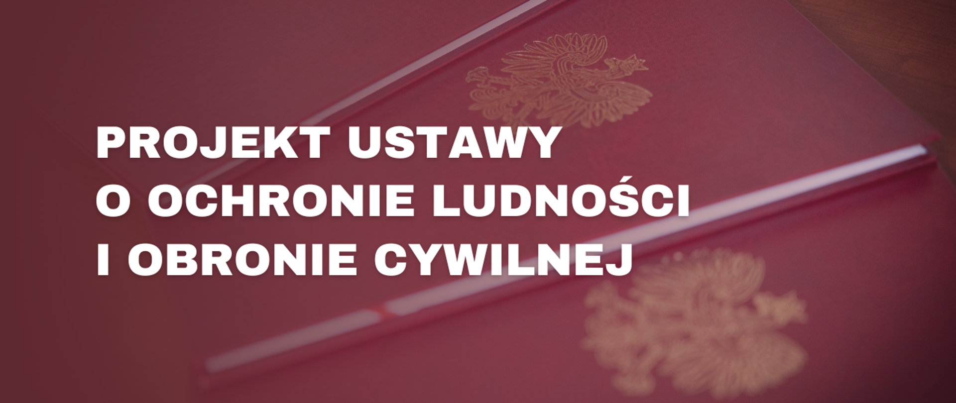 Treść: Projekt ustawy o ochronie ludności i obronie cywilnej. W tle znajdują się bordowe teczki z orłem.