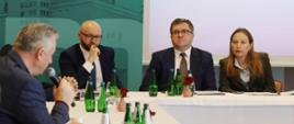 Na zdjęciu minister Katarzyna Pełczyńska-Nałęcz siedzi za stołem w towarzystwie innych uczestników spotkania