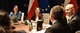 Uczestnicy spotkania rozmawiają przy okrągłym stole.