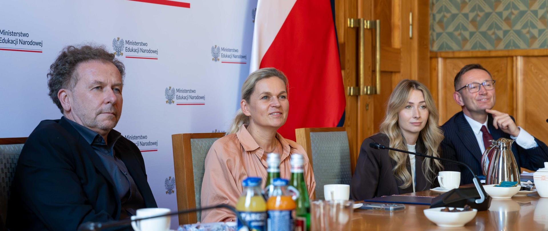Minister Edukacji Barbara Nowacka siedzi przy stole wraz z Dyrektorem Generalnym. Słucha rozmów.