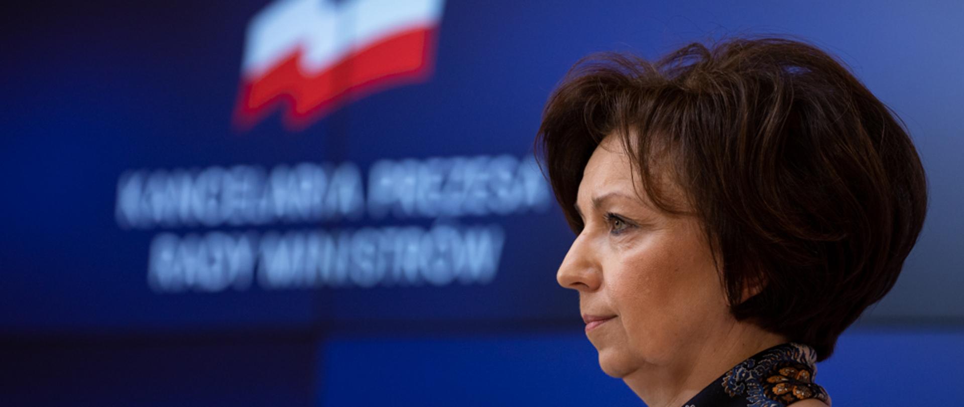 Minister Marlena Maląg na tle ścianki wizyjnej.