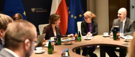 Uczestnicy spotkania rozmawiają przy okrągłym stole.
