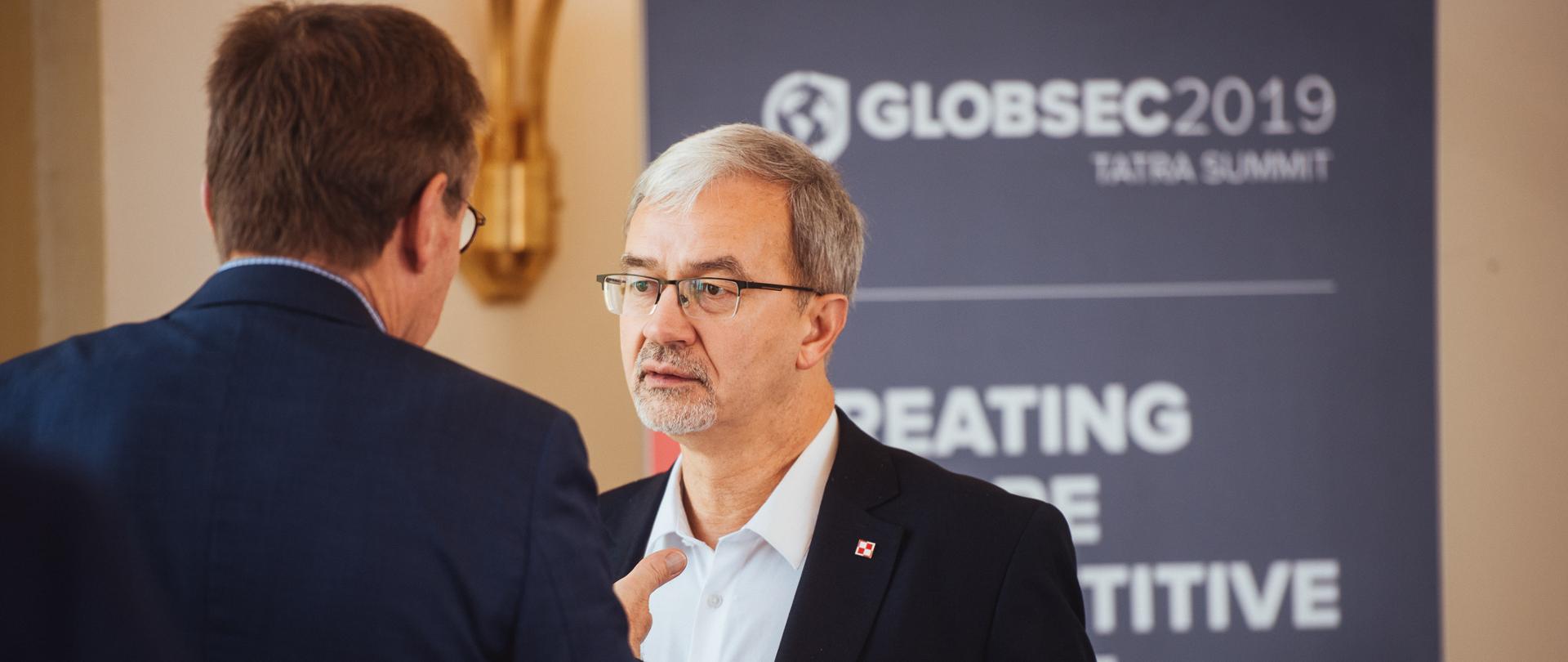 Minister Jerzy Kwieciński na tle banera Globsec2019