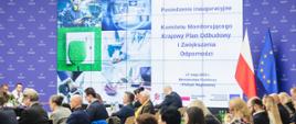 Posiedzenie inauguracyjne Komitetu Monitorującego Krajowy Planu Odbudowy i Zwiększania Odporności - na zdjęciu grafika z napisem informującym o posiedzeniu KM KPO oraz uczestnicy obrad