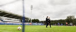 Premier Mateusz Morawiecki i prezes Lecha Poznań idą po murawie.