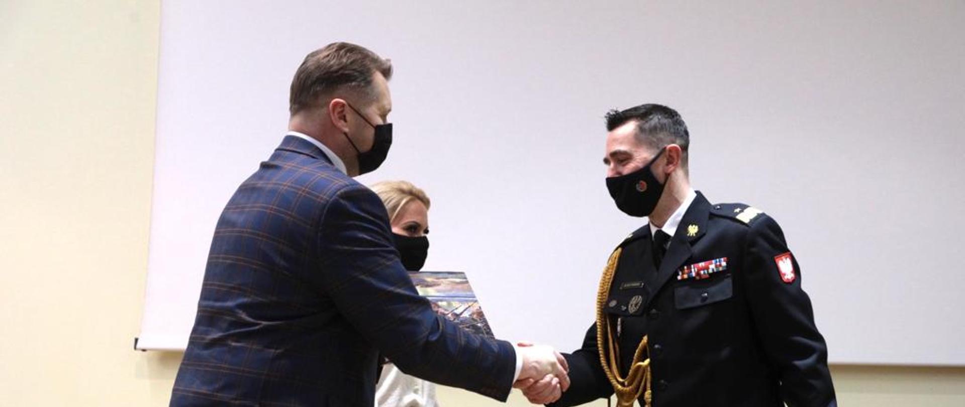 40. rocznica utworzenia Szkoły Głównej Służby Pożarniczej z udziałem ministra Przemysława Czarnka, minister Przemysław Czarnek podaje rękę przedstawicielowi Szkoły Głównej Służby Pożarniczej.